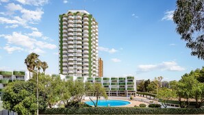 Ein Hochhaus-Hotel mit mehreren Balkonen, einem Schwimmbad und üppiger Bepflanzung.