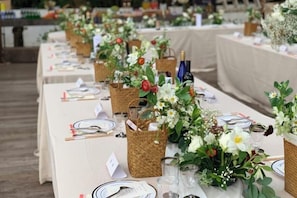 A long table set with wicker baskets, glassware, and floral centerpieces. - Yin xiang lin yin Hotel (Hangzhou)