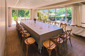 Ein Konferenzraum mit langem Tisch, Stühlen und Blick ins Freie.