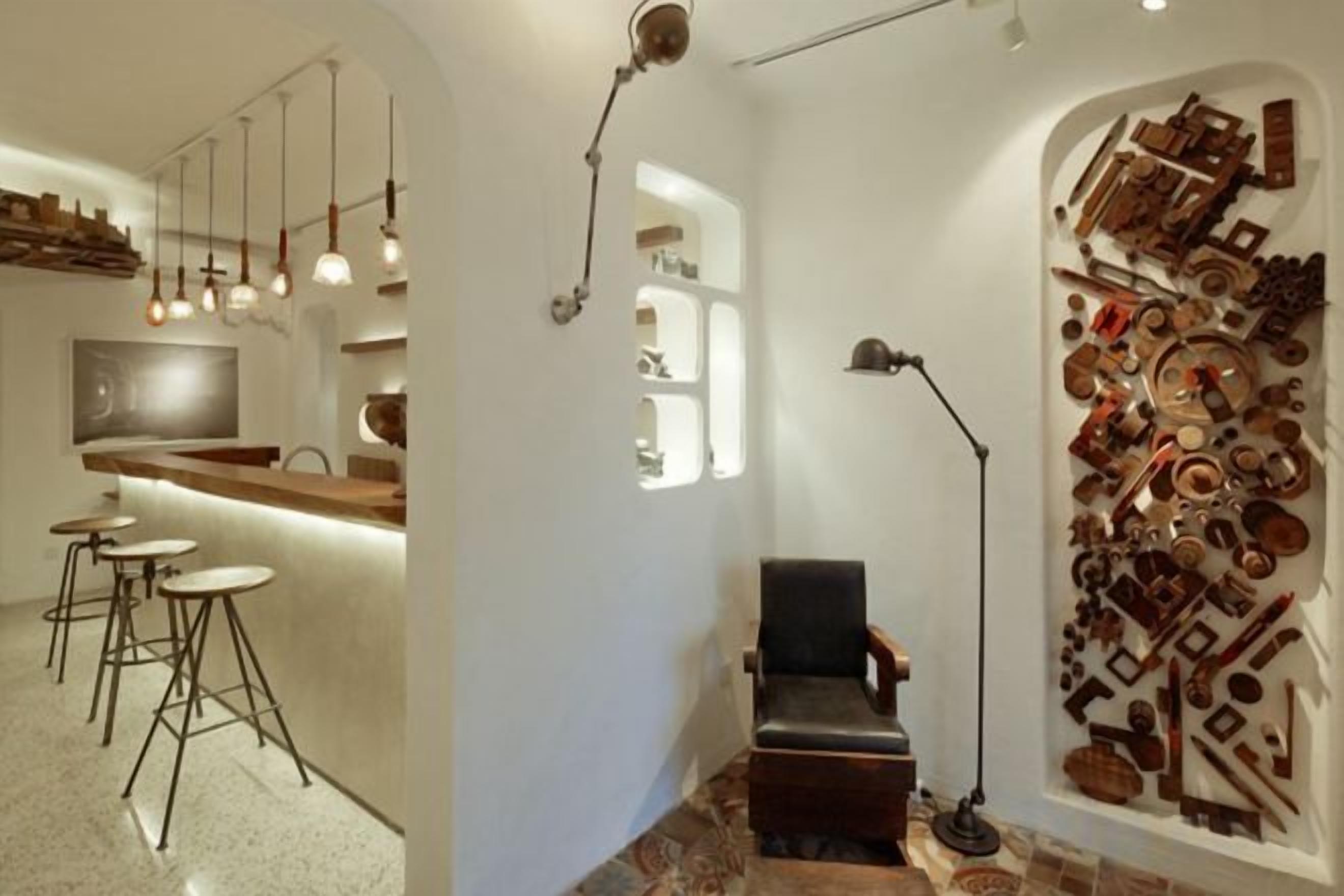 Un interior moderno con una zona de bar, asientos y una exposición de arte en la pared.