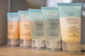A row of Eco Botanics hair care products on a shelf. - Deluxe Queen Room with View and Ensuite Bath (San Francisco)