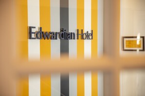 Señal del Hotel Edwardian con fondo a rayas.