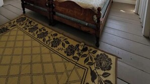 A bedroom with a wooden bed, a window with a view, and a door leading to another room. - Quaint quarters in South Wellfleet (Wellfleet)