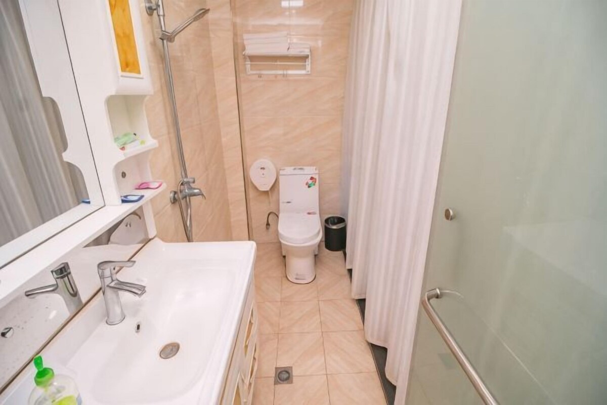 A bathroom with a sink, mirror, toilet, and shower.