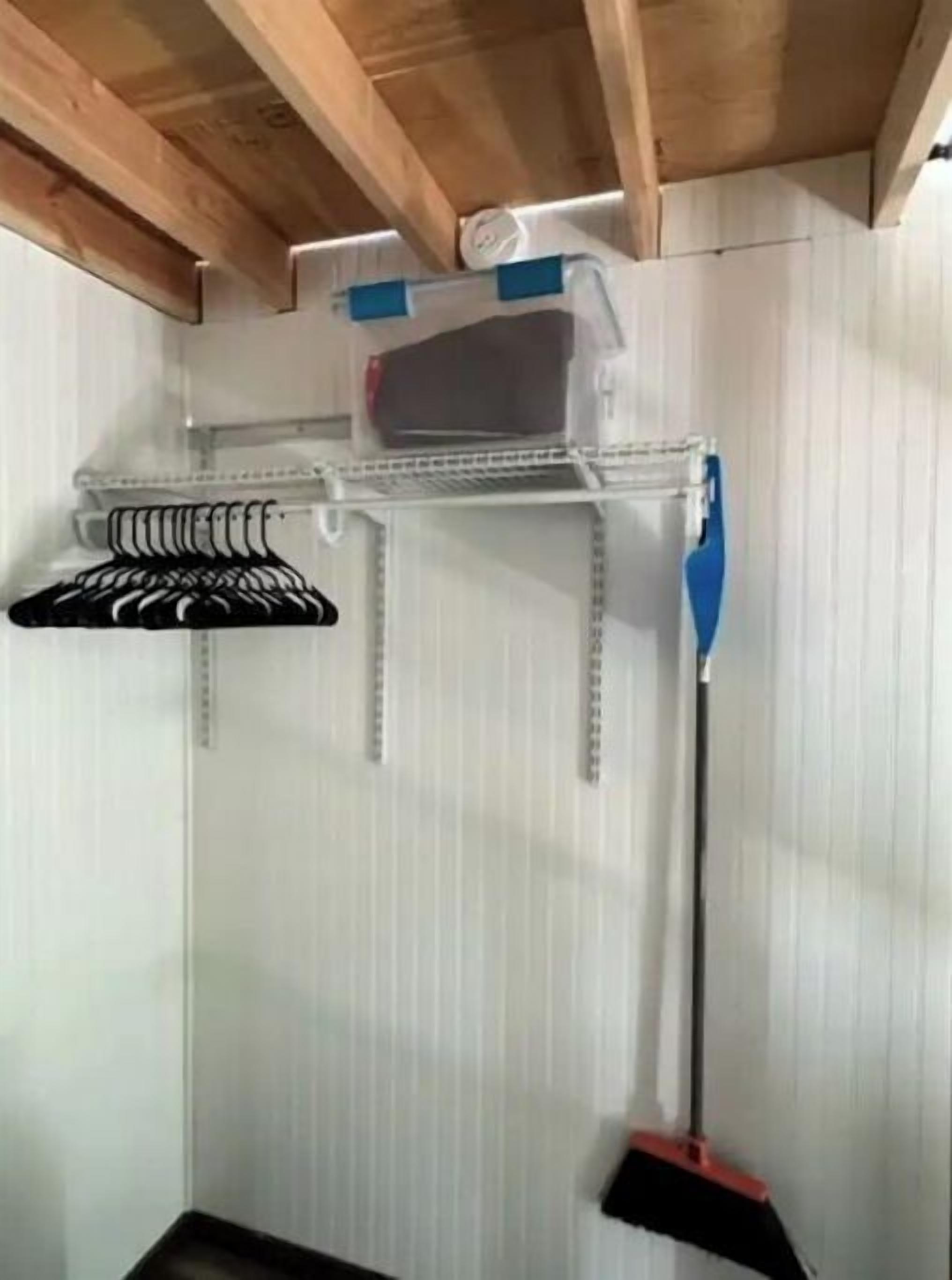 A storage rack with hanging items and a broom.