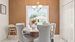 A dining room with a round table, four chairs, a vase with flowers, and a chandelier. - Entire House 5 Minutes to Silver Springs State Park in Ocala, Florida/ Sleeps 12 (Ocala)