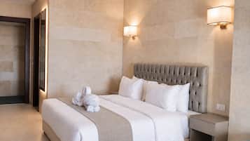 Een hotelkamer met een groot bed, een hoofdeinde, twee wandlampen en een nachtkastje.