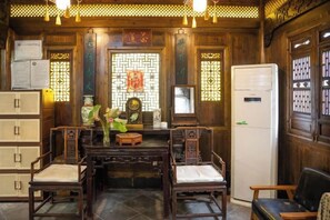 A traditional room with wooden furniture, a central table, and a refrigerator. - Building A, Futongyuan Inn, Tianqi Hongcun, Huangshan (Yi County)
