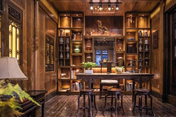 A traditional interior with a central bar area, wooden shelves with decorative items, and a patterned floor.
