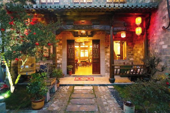 A traditional Chinese-style building with a stone pathway leading to a wooden door.