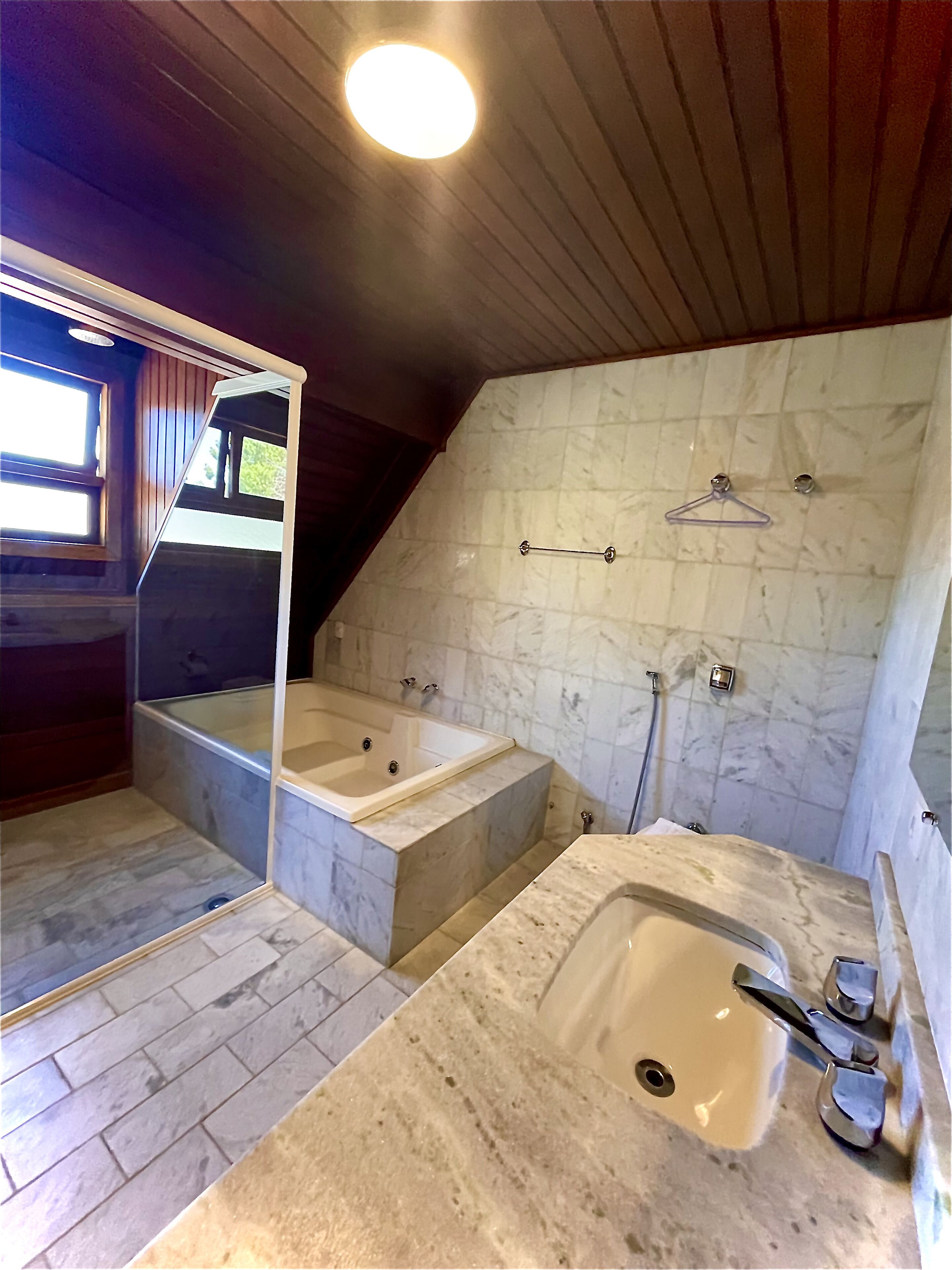 A bathroom with a large bathtub, a separate shower area, and a sink with a marble countertop.