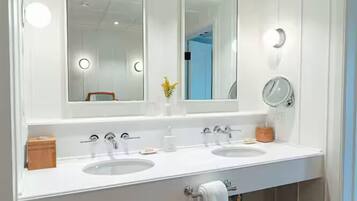 A bathroom with two sinks, a mirror, and a towel rack.
