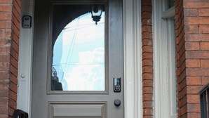 A gray door with a white frame, a black doorbell, and a hanging lantern. - Brand New 4bd, 2ba Lancaster Center City Townhome (Lancaster)
