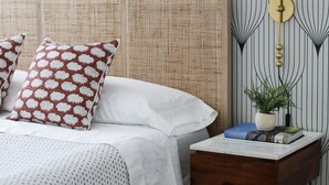 A bedroom with a bed, pillows, a bedside table with a lamp, and a patterned wall. - Brand New 4bd, 2ba Lancaster Center City Townhome (Lancaster)