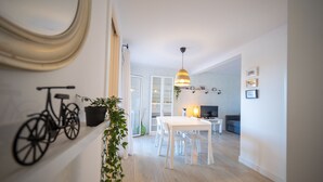A modern living space with a dining area, a television, and a bicycle mounted on the wall.