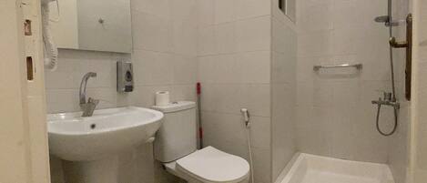 A bathroom with a sink, toilet, bidet, and bathtub.