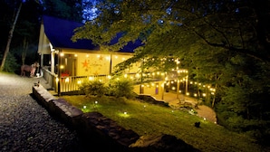 A building with a covered porch, string lights, and a star decoration. - Luxury Blue Ridge Cabin with Hot Tub & Game Room - Sleeps 8 (Ferguson)