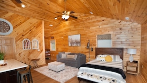 A log cabin bedroom with a bed, a desk, and a chair. - Luxury cabin with mountain views (Flintstone)