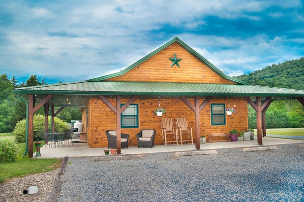 A wooden lodge with a green roof, outdoor seating, and a star emblem.