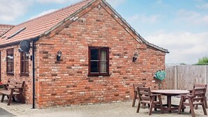 A brick building with a pitched roof, a window, and a door. - 1 bedroom accommodation in Addlethorpe, near Skegness (Addlethorpe, near Skegness)