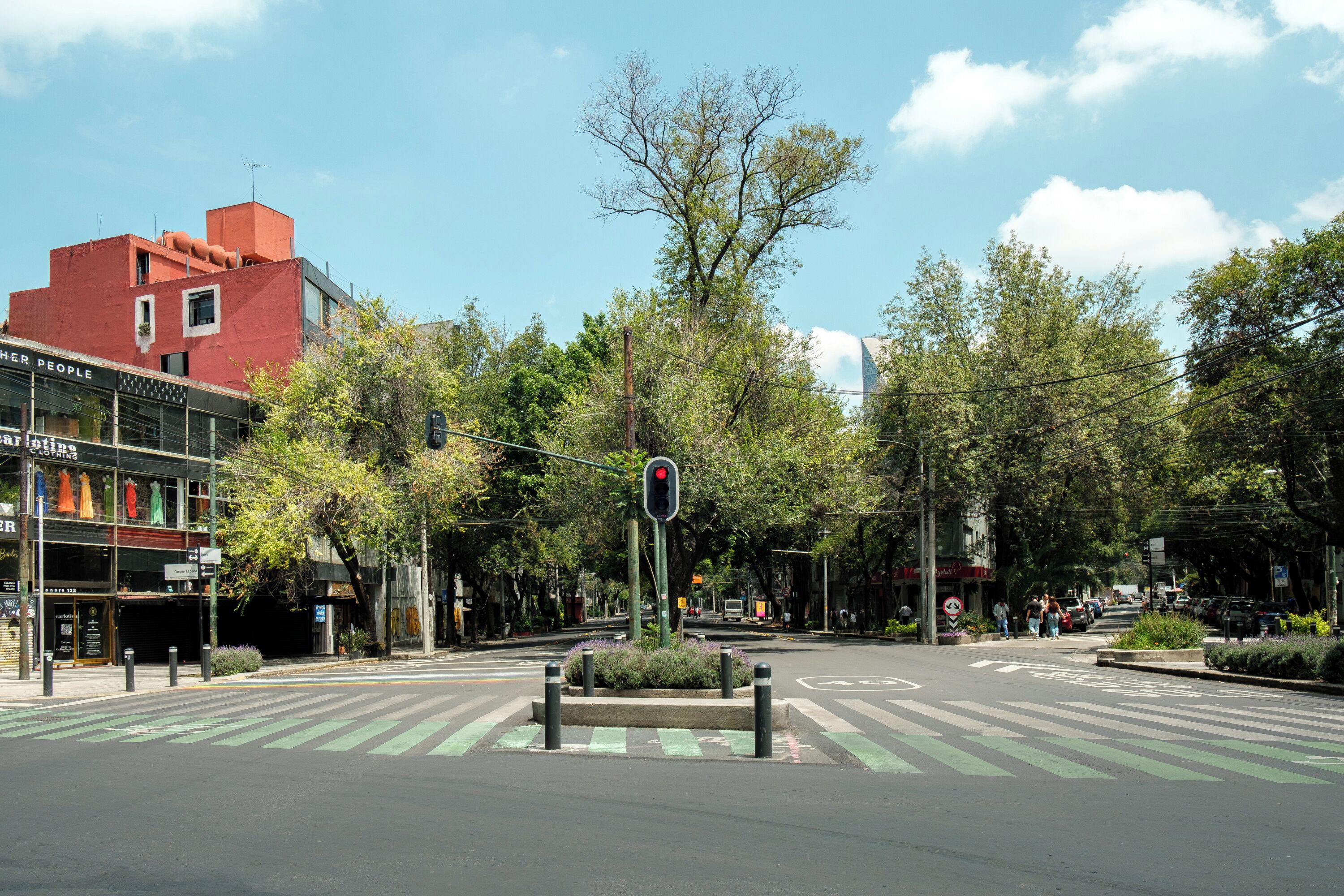 A street intersection with traffic lights, crosswalks, and buildings.