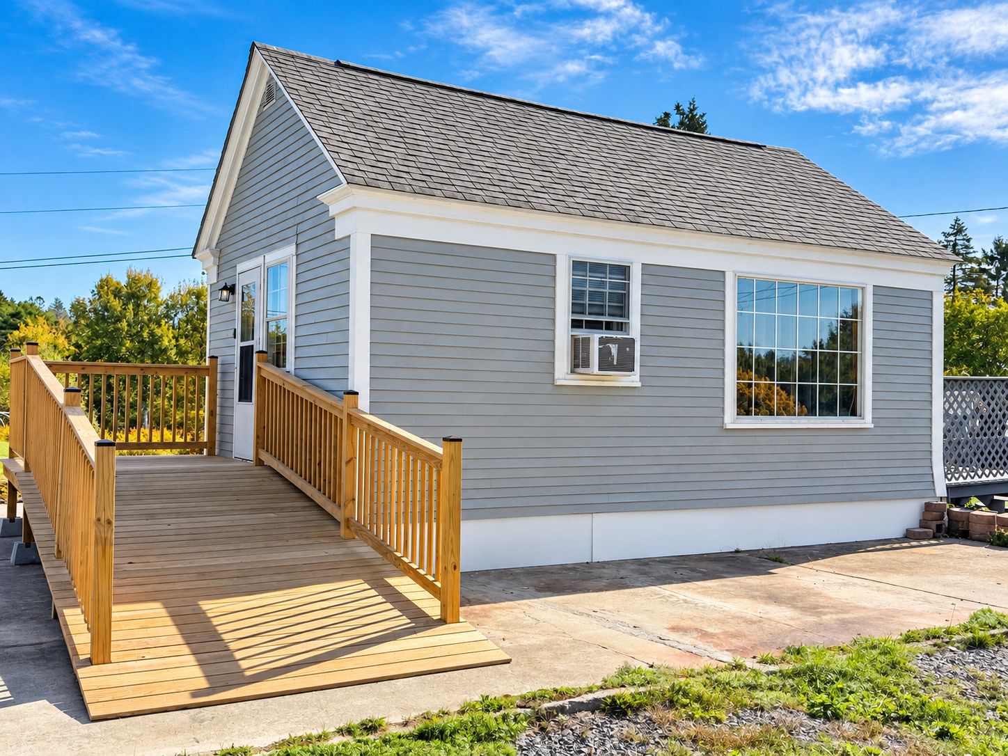 A single-story house with a wooden deck, a small porch, and a garage.