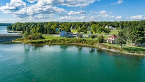 A lakeside property with multiple houses, a dock, and a clear view of the lake.