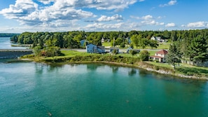 A lakeside property with multiple houses, a dock, and a clear view of the lake.