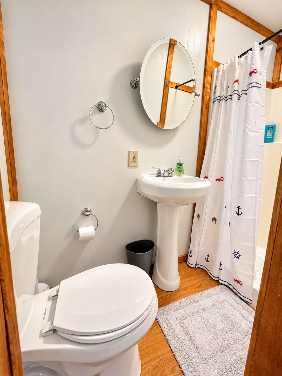 Une salle de bain équipée de toilettes, d’un lavabo, d’un miroir et d’un rideau de douche.