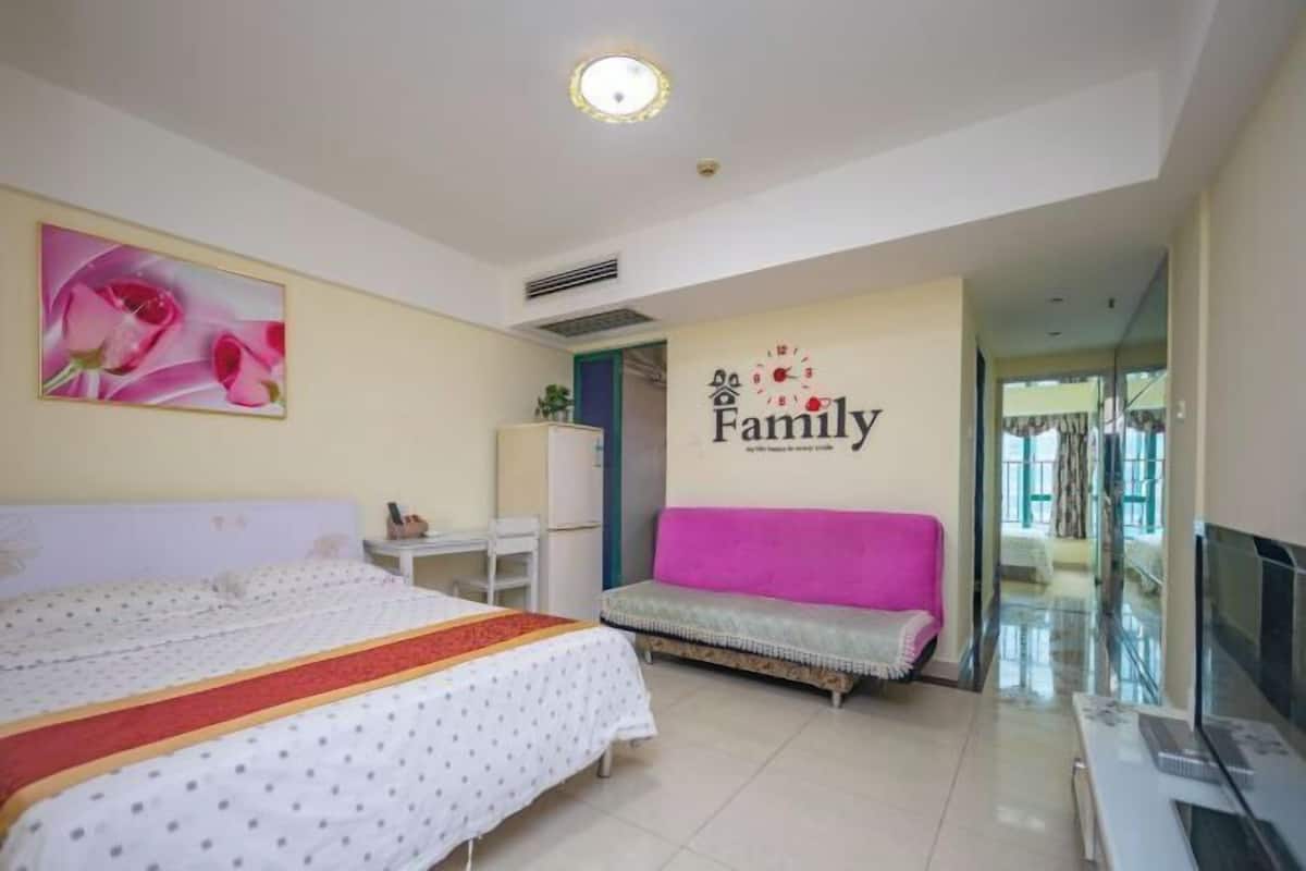Un dormitorio con una cama, un sofá, un televisor y una pared con un cartel que dice 'Familia'.
