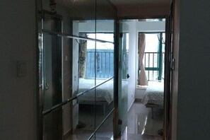 Quarto com porta de vidro que dá para uma varanda.