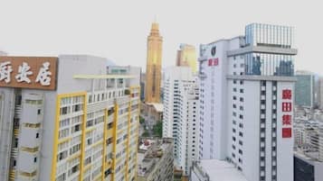 Um edifício alto com uma placa grande em idioma estrangeiro, cercado por outros edifícios imponentes em um ambiente urbano.
