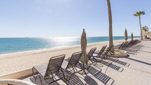 A beachside lounge with sun loungers and umbrellas, palm trees, and a clear view of the ocean. - Oceanfront View- Sandy Beach-Sonoran Sea Resort (Puerto Peñasco)