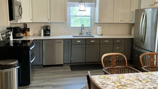 A kitchen with white cabinets, a stainless steel refrigerator, a coffee maker, and a sink. - Historic House in heart of Altenburg (Altenburg)