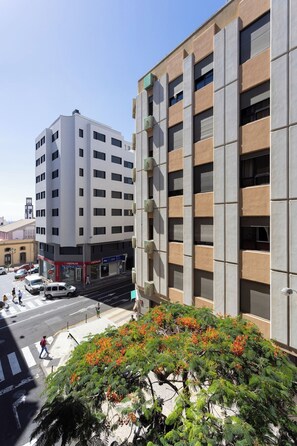 A multi-story building with a modern architectural design, featuring a mix of rectangular and square windows, and a flat roof.