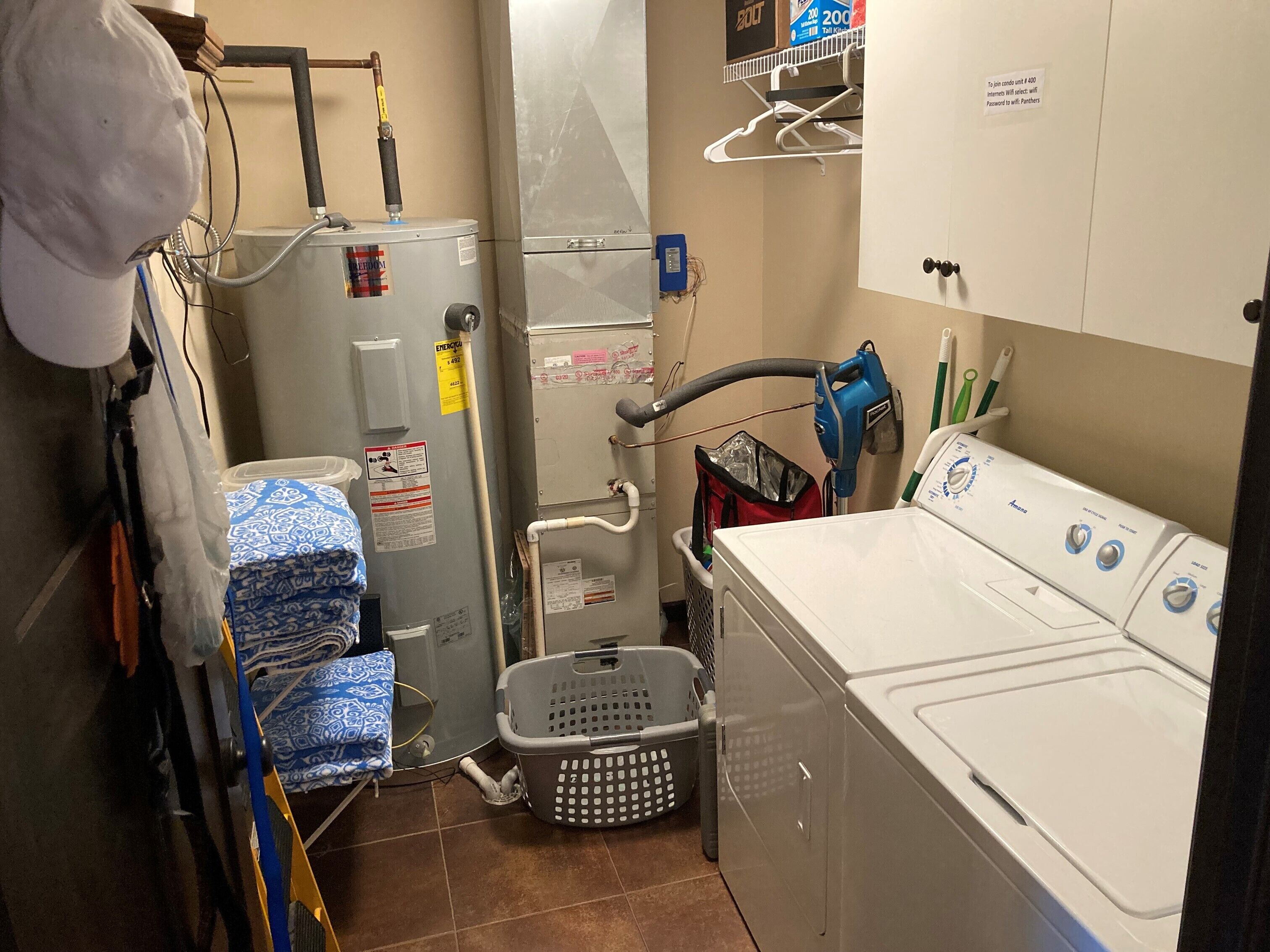 Ein Waschraum mit einer Waschmaschine und einem Trockner, ein Hauswirtschaftsraum mit Elektroheizung und ein Hauswirtschaftsraum mit Kleiderstange.