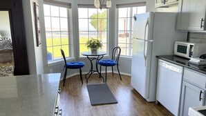 A kitchen with a dining table, chairs, a refrigerator, a microwave, and a dishwasher. - Wine Country Getaway with Amazing Views (Kennewick)