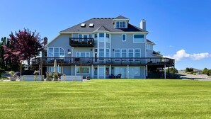 A large two-story house with a covered front porch and a spacious lawn. - Wine Country Getaway with Amazing Views (Kennewick)