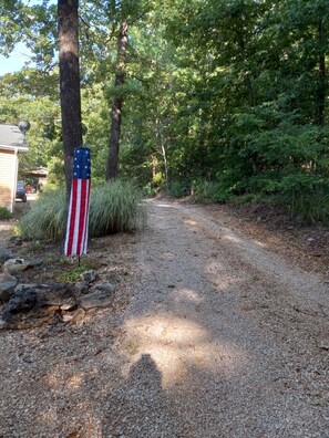 Enter a serene wooded retreat with a flagpole bearing the American flag.
