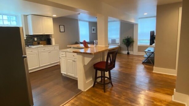 A spacious kitchen with white cabinets, a wooden countertop, and a bar stool. - GORGEOUS NEW RENNOVATED APT! 1 month or more! Calling TRAVEL NURSES! (Gloversville)