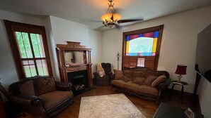 A living room with a fireplace, two sofas, a coffee table, and a rug. - Downtown Dream in Owensboro Ky (Owensboro)