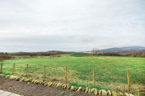 A rural landscape with a stone wall and wooden fence.