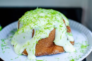 Un gâteau recouvert de glaçage blanc et décoré de motifs verts, présenté sur une assiette blanche.