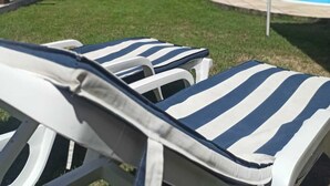 A poolside area with lounge chairs and a covered patio. - Vila Gameleira Garça Torta (Maceió)
