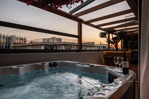 Ein Whirlpool mit Blick auf Gebäude und einen Sonnenuntergang.