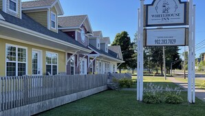 A Wheelhouse Inn with a signboard, a wooden fence, and a well-maintained lawn.