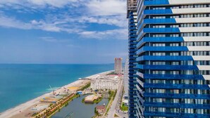 A high-rise hotel with a view of the beach and ocean.