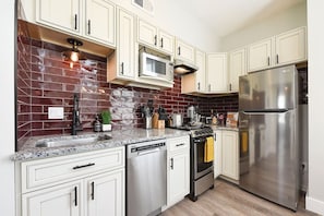 Enjoy cooking in this well-equipped kitchen with a gas stove, microwave, and refrigerator.