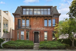 Stunning two-story building with a flat roof and balcony, set amidst beautifully maintained gardens.