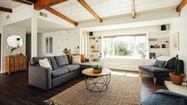 A spacious living room with a large window, wooden beams, and a cozy seating area. - Family Retreat with Pool and Hot Tub (Vista)